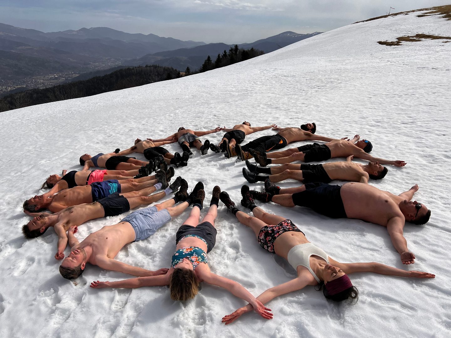 Une équipe allongée en étoile sur la neige, unie