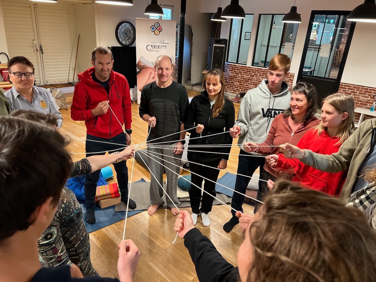 Un groupe relié par un fil lors d'un atelier de connexion en équipe